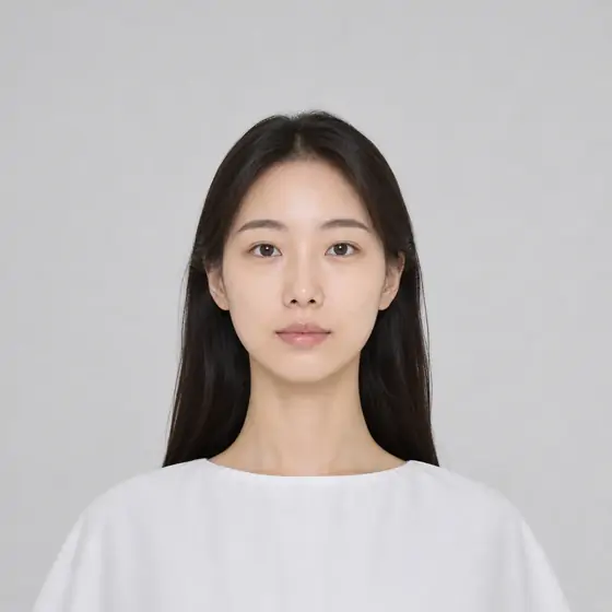 白いトップスを着て正面を向く、長い髪の女性の顔写真の例。AIで作成した架空の人物です。